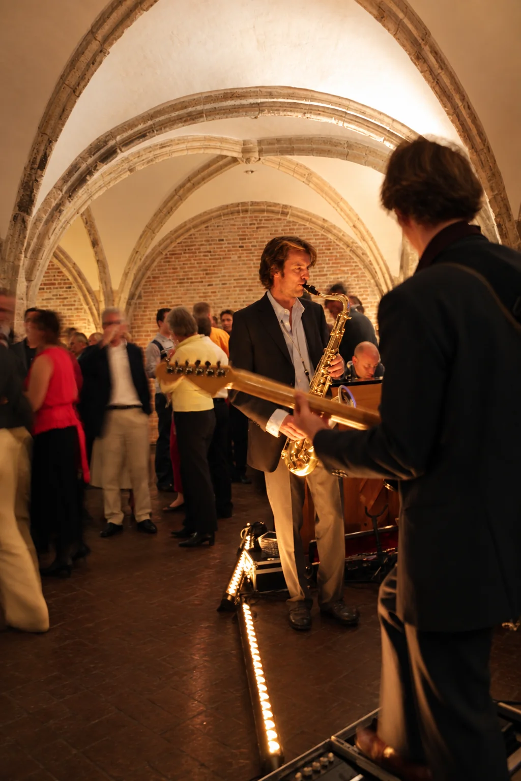 Live muziek met een saxofonist tussen de gasten in De Raedtskelder