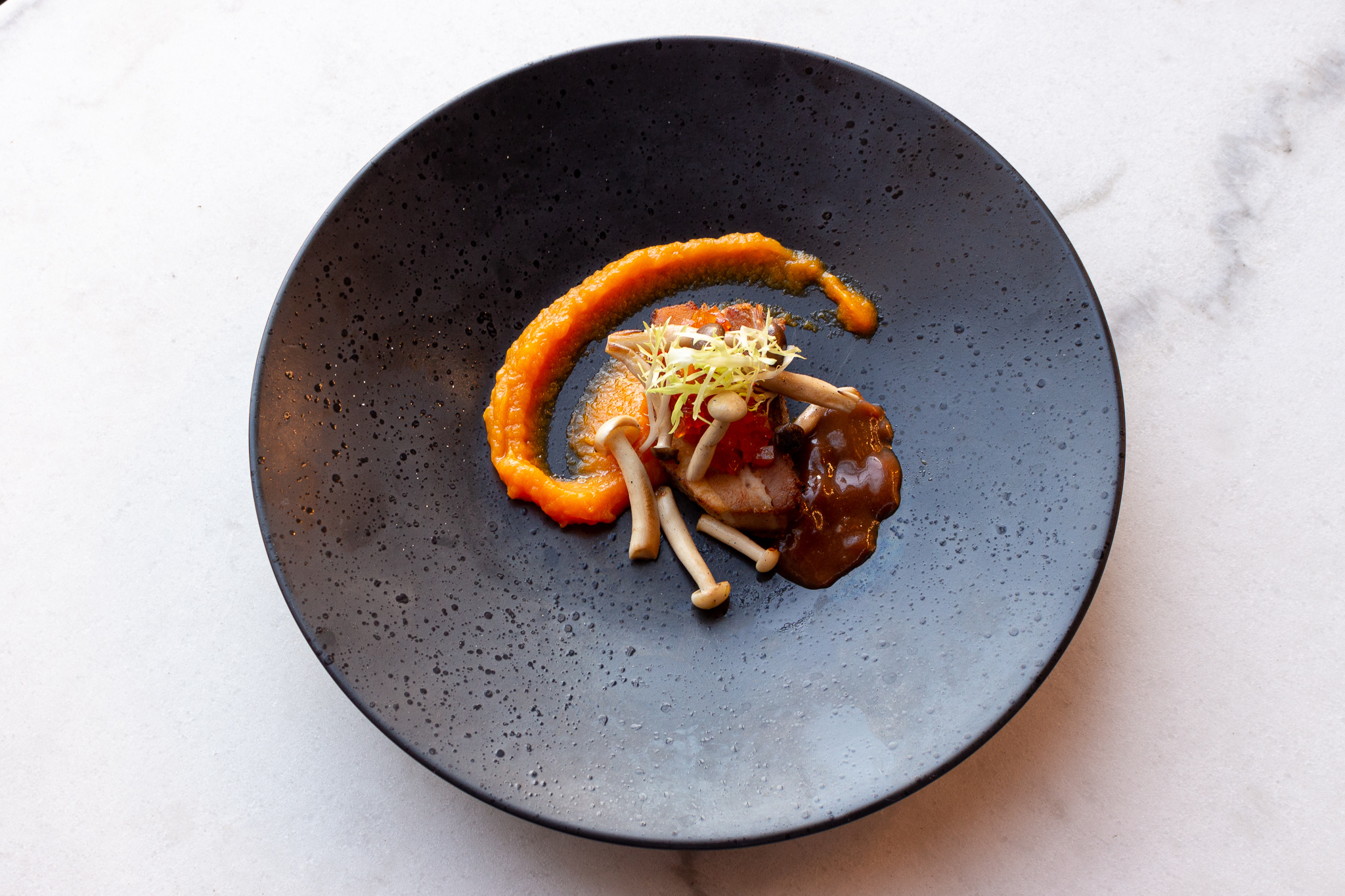 Een gerecht uit onze keuken, opgemaakt op een donker bord